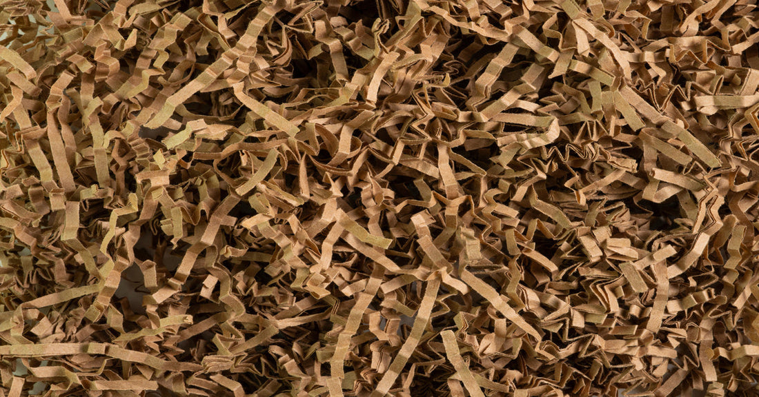 A pile of brown cardboard scraps shredded and folded into thin strips. All the straps are the same shade of brown.